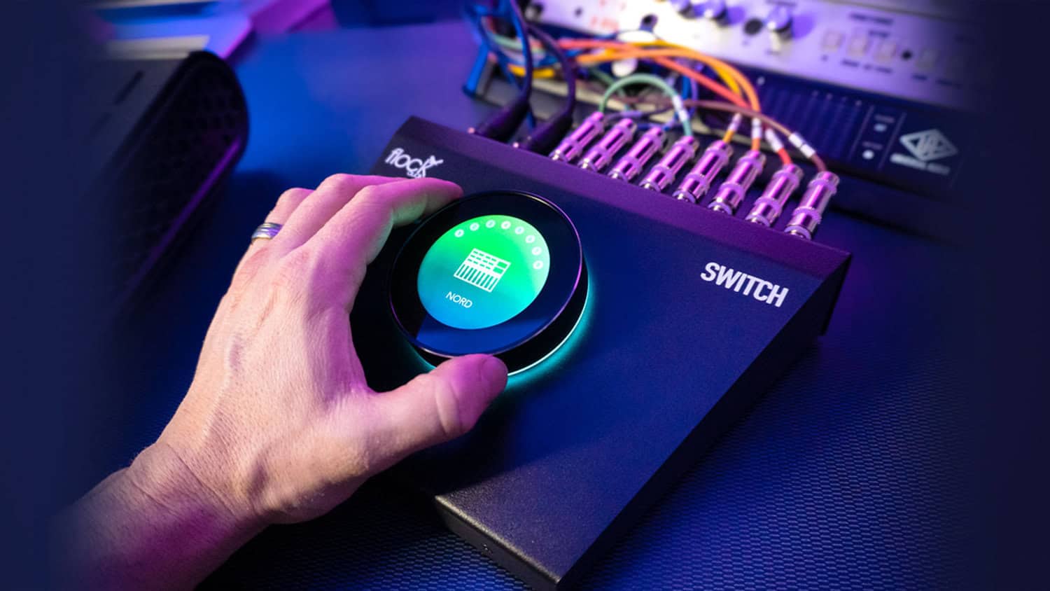 Person controlling the Flock Audio Switch on a table.